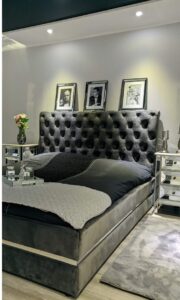 Nowoczesny salon z musztardową sofą narożną M145 o pikowanym siedzisku i złotych nogach, ustawioną w jasnym, minimalistycznym wnętrzu.