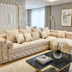 Luksusowy salon z dużą, beżową sofą M125 w kształcie litery L, ustawioną na jasnym