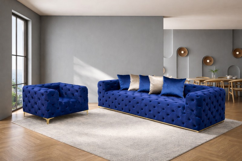 Sofa i fotel M012 Mebel Akimo w granatowym welurze, pikowane, na złotych nogach w nowoczesnym salonie.